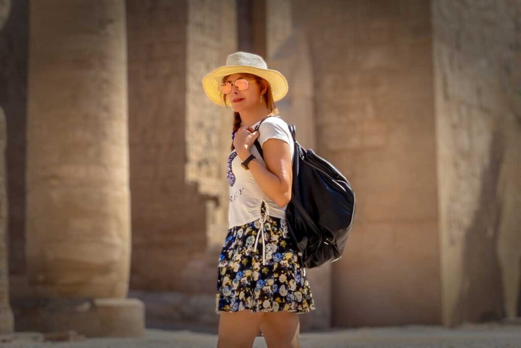 Beebee luciendo una faldita corta y una camiseta blanca, frente al templo de Karnak