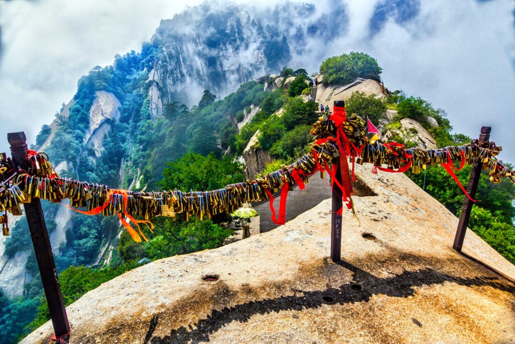 Tarimas que cuelgan directamente sobre un abismo de piedra caliza, recorre el sendero más impresionante del mundo en la montaña sagrada de Huashan, provincia de Shaanxi, China